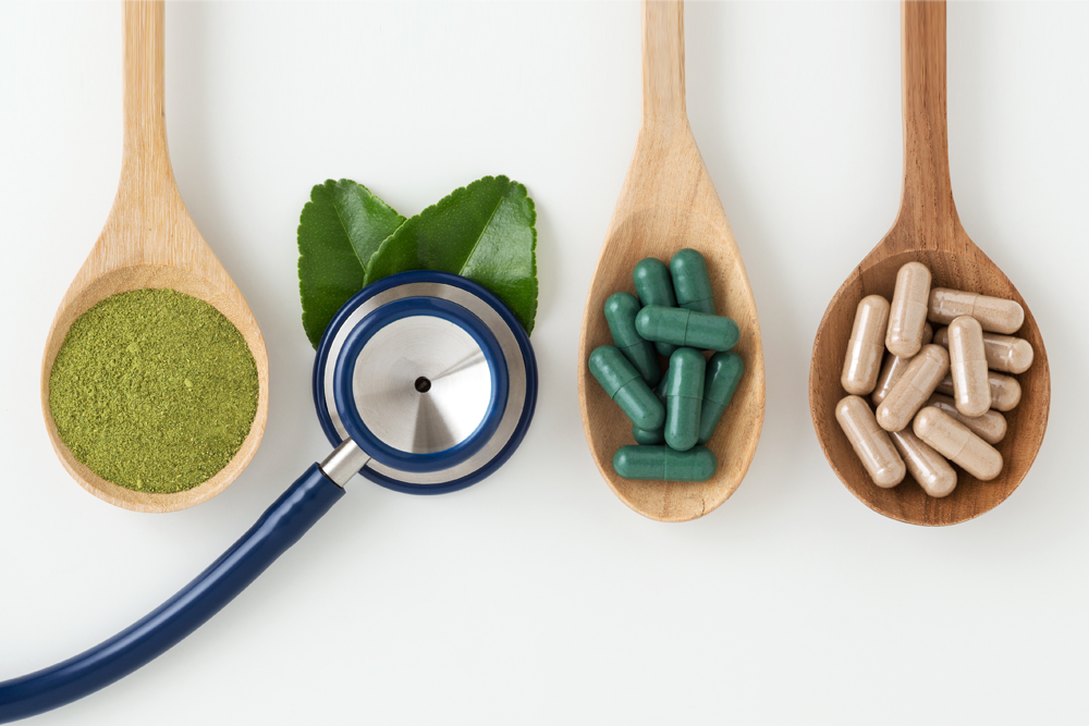 Wooden spoons serving up herbs, supplements and a stethoscope
